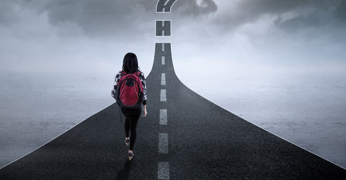 woman walking along a road going to nowhere