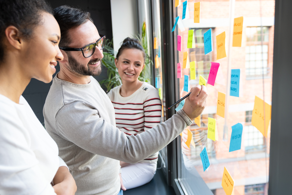 Team mapping AI adoption ideas with sticky notes during a practical workplace workshop